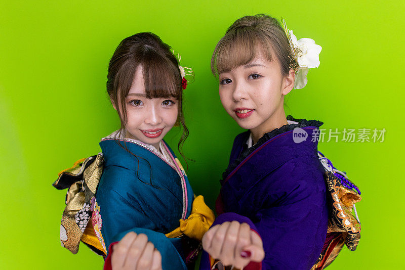 身着Furisode和服的年轻女子在“Purikura”照片贴纸摊上为“Seijin Shiki”成人礼拍照